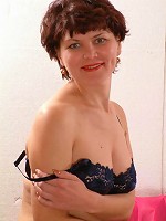 Experienced mature model playfully stripping off her clothes to show off her perky boobs